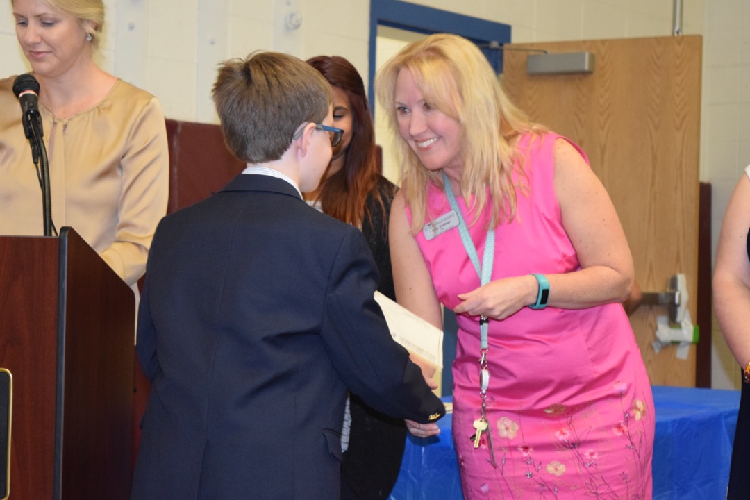 Tim receives his certificate from Mrs. Erdman