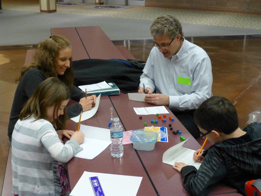 Dad and Ted work on a math game at the Equations district event