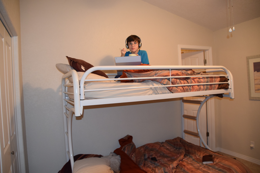Hanging out in the bunk bed with ice cream and his Chromebook