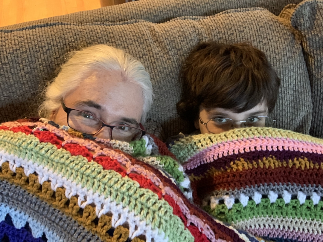 Mom and Ted take cover under a crocheted blanket gift