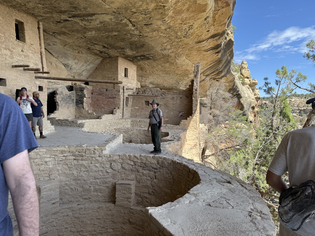 Ray stands near the edge and talks about kivas